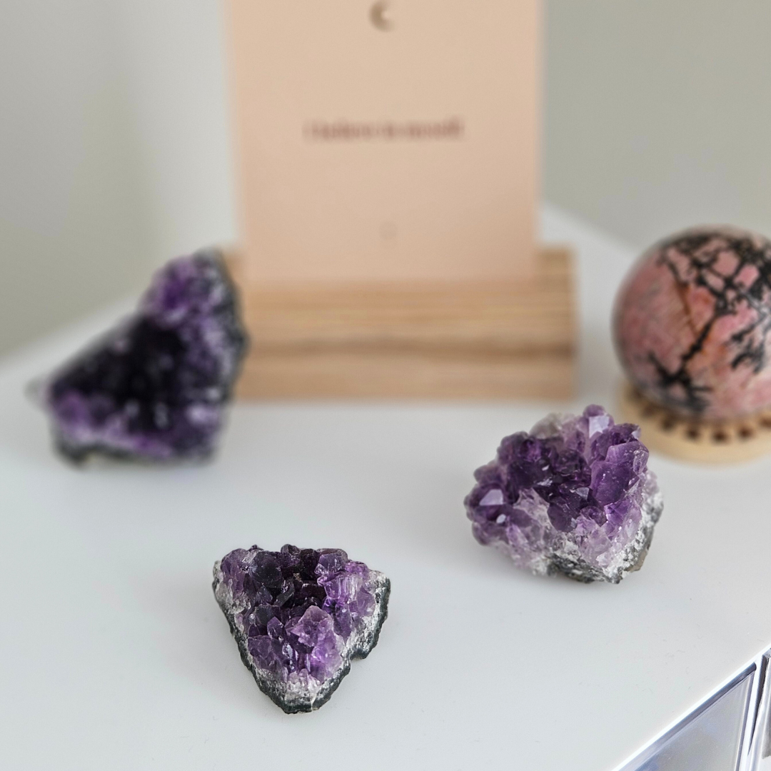 Amethyst crystal on a white surface with a blurred background