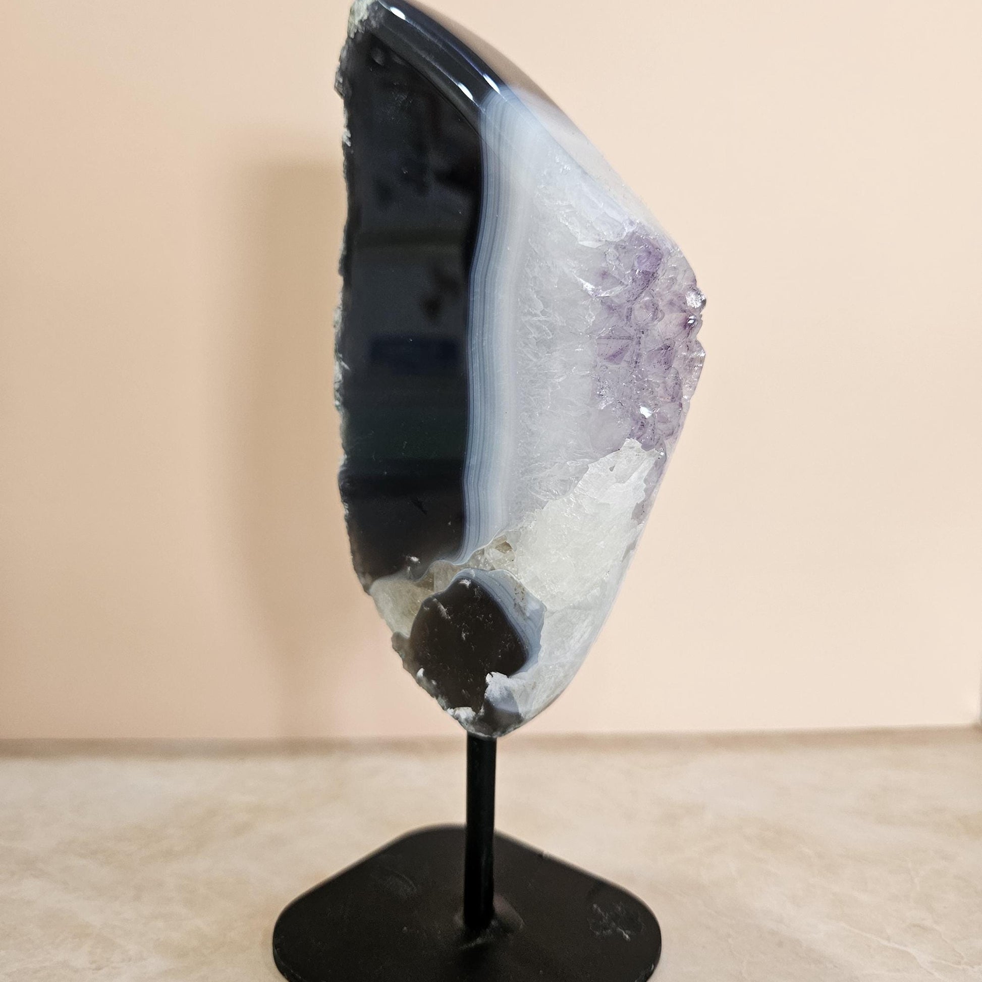 Geode crystal on a stand against a beige background