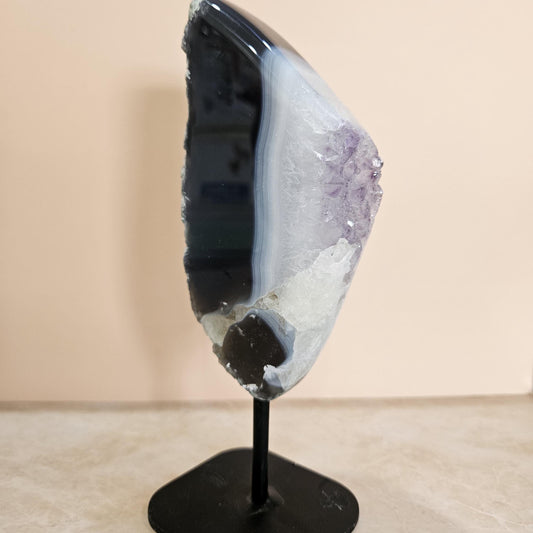 Geode crystal on a stand against a beige background